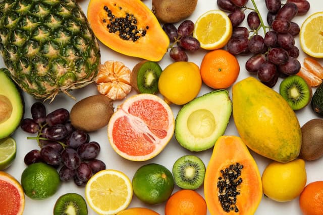 A variety of different fruits lying on a white table.
