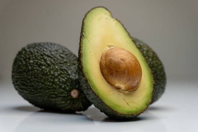 three avocados, one standing up sliced in half