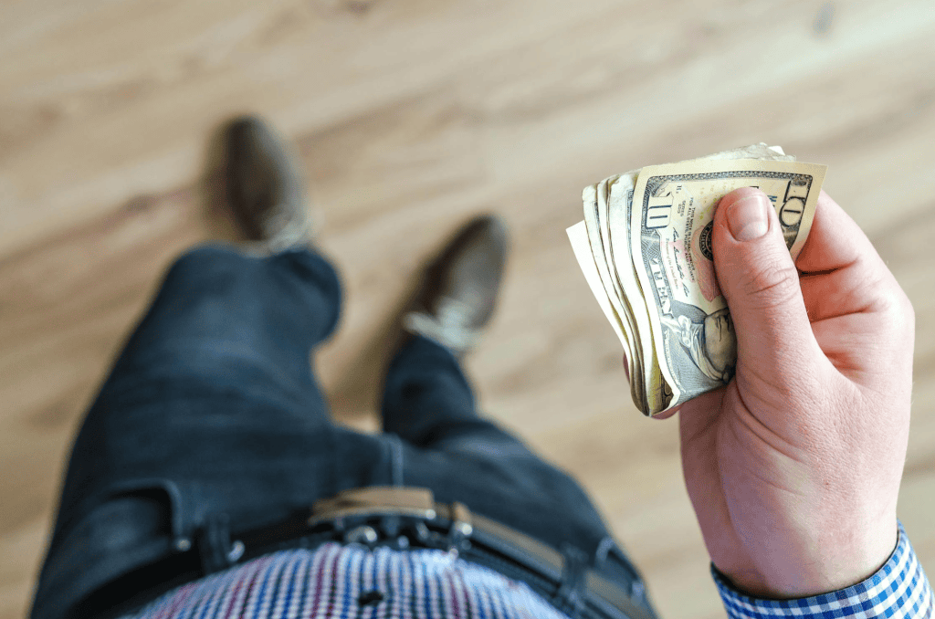 A man holding some ten dollar bills.
